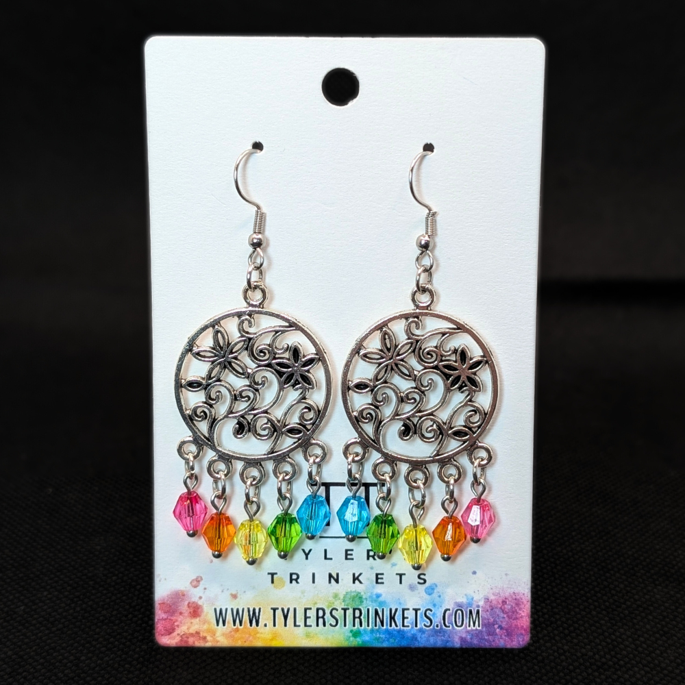 Dangle earrings made from a circular metal charm with a flower pattern in the center and multi-colored beads on an ear-wire style hook.