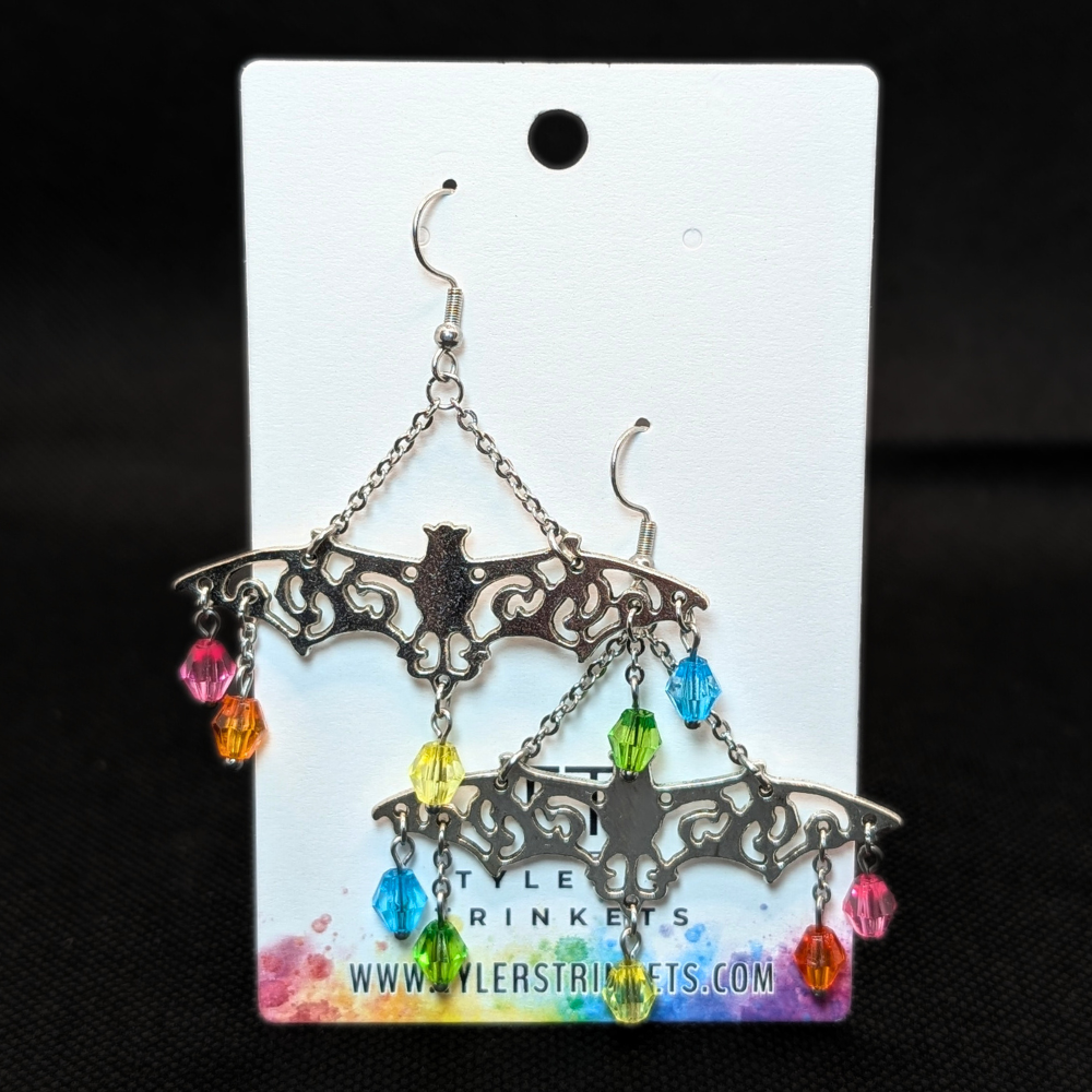 Dangle earrings made from a metal bat-shaped charm and multi-colored beads on an ear-wire style hook.