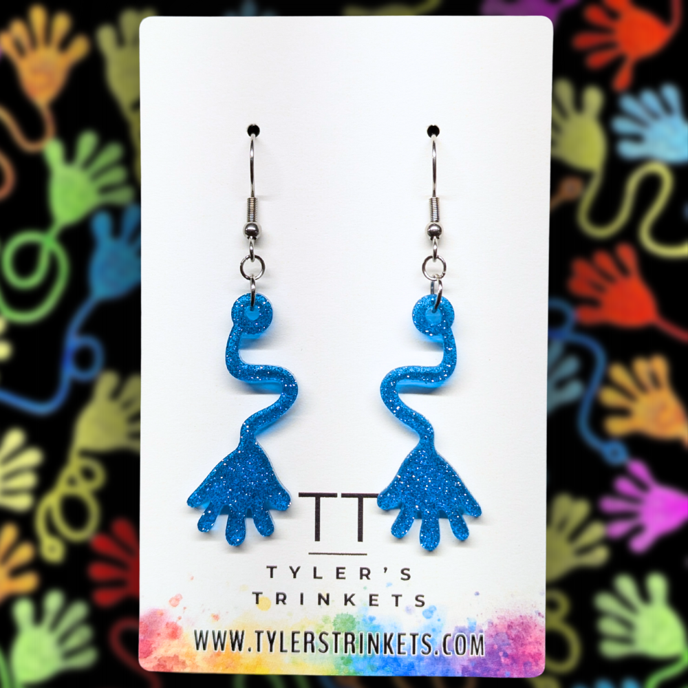 Dangle earrings made from a blue resin charm shaped like a sticky-hand novelty toy, suspended on an ear-wire style hook.